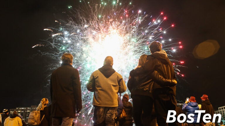 People watch early fireworks during First Night festivities on December 31, 2015.