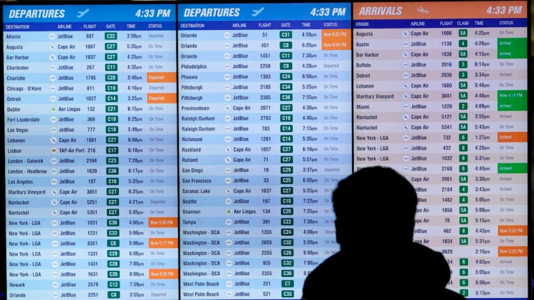 A traveler reads a flight board Tuesday in Terminal C at Boston Logan International Airport.