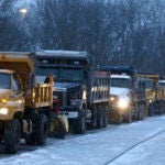 Row of snowplows headed down the street