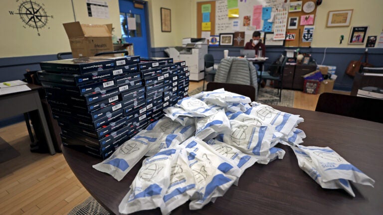 COVID test kits and masks on the table for teachers to pick up at the Donald McKay K-8 school in East Boston
