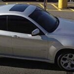 alt = passenger side of a silver 2014 BMW X6 with Connecticut registration, AH38573, in a parking lot