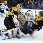 Tampa Bay Lightning center Ross Colton (79) crashes into Boston Bruins goaltender Linus Ullmark (35) after a scheme by defenseman Brandon Carlo (25) during the second period of an NHL hockey game Thursday, Jan. 26, 2023, in Tampa, Fla.