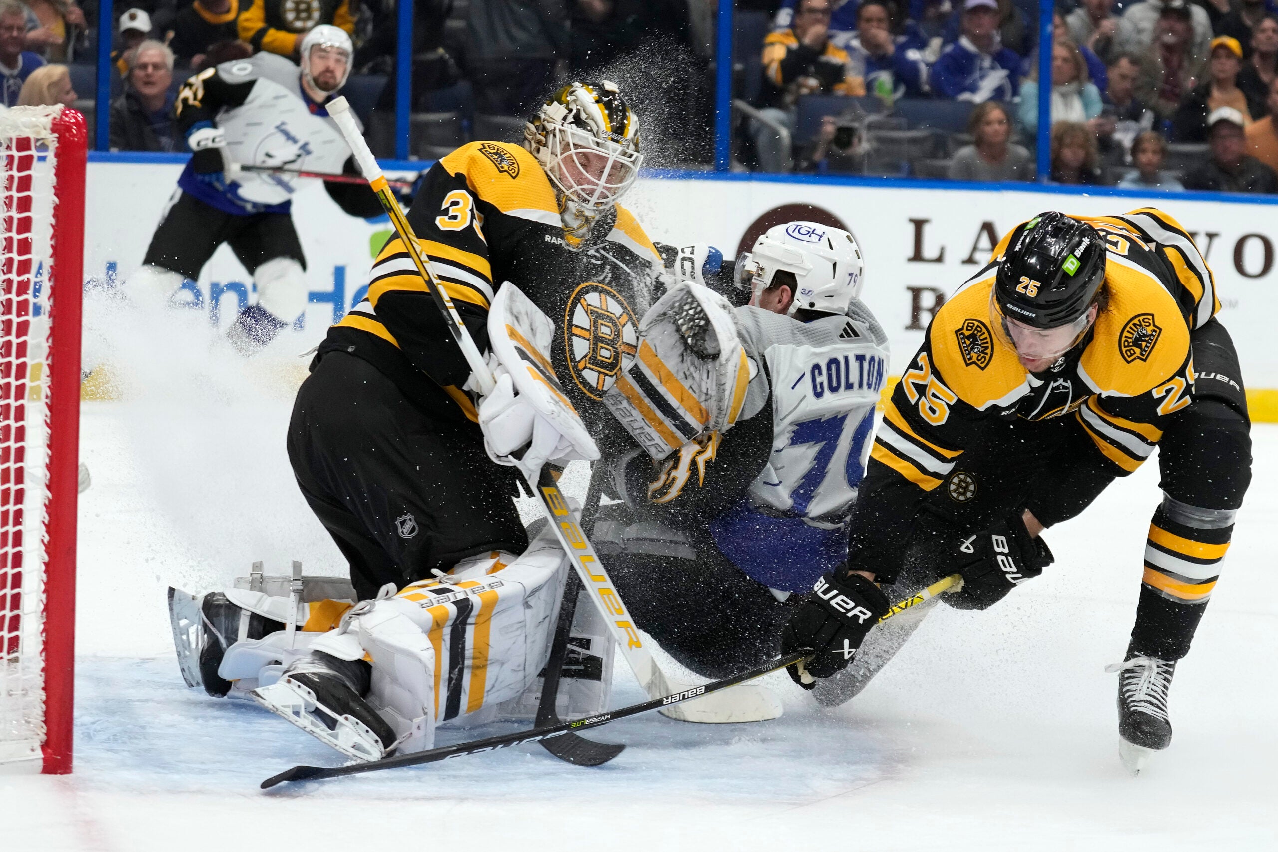 Tampa Bay Lightning center Ross Colton (79) crashes into Boston Bruins goaltender Linus Ullmark (35) after a scheme by defenseman Brandon Carlo (25) during the second period of an NHL hockey game Thursday, Jan. 26, 2023, in Tampa, Fla.