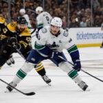 Boston Bruins' Nick Foligno (17) tries to slow down Vancouver Canucks' Bo Horvat during the third period of an NHL hockey game Sunday, Nov. 13, 2022, in Boston.