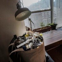 A bag of trash sits on a chair near the window in Josh Spodek's Greenwich Village apartment, where he's ditched his refrigerator for sustainable living, Tuesday Jan. 24, 2023, in New York. Spodek says he has not taken out the trash since 2019, having not produced enough non-compostable and non-recyclable waste during his effort to reduce his carbon footprint.