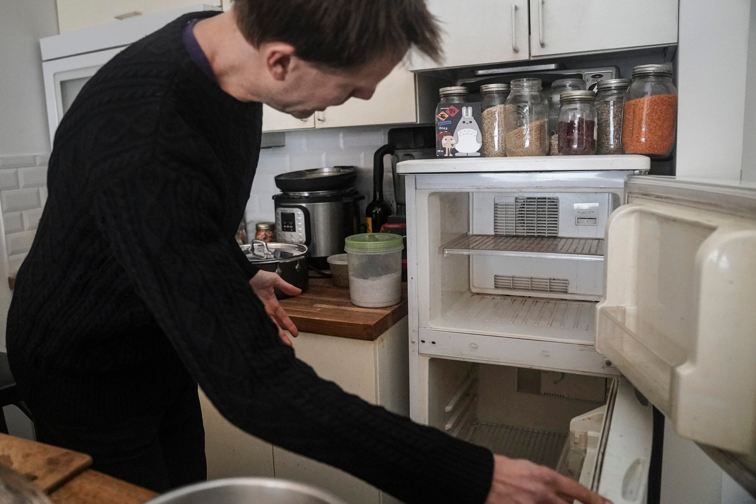 Josh Spodek shows the empty refrigerator in his Greenwich Village apartment he ditched to support his effort to cut his carbon footprint. Beyond the energy savings, Spodek says without a refrigerator he has learned to cook better and develop fermentation techniques using a wider variety of seasonal produce. 