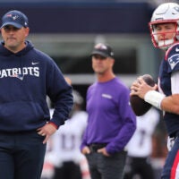 Both Patriots quarterback coach Joe Judge (left) and Ravens head coach John Harbaugh (backround center) were watching as New England quarterback Mac Jones (10) was warming up before the start of the game.