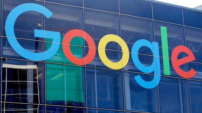 alt = A sign is shown on a Google building at their campus in Mountain View, Calif. featuring the classic blue, red, yellow, and green logo.