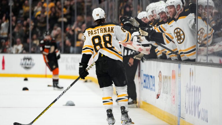 Boston Bruins' David Pastrnak (88) celebrates his hat-trick goal with teammates during the second period of an NHL hockey game against the Anaheim Ducks Sunday, Jan. 8, 2023, in Anaheim, Calif.