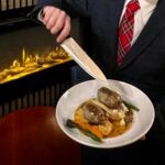 The Haven owner Jason Waddleton serves haggis in front of the fire