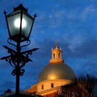 Light catches the dome of the Massachusetts State House as the sun sets in Boston on Jan. 6, 2021.