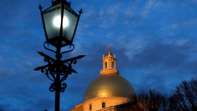 Light catches the dome of the Massachusetts State House as the sun sets in Boston on Jan. 6, 2021.
