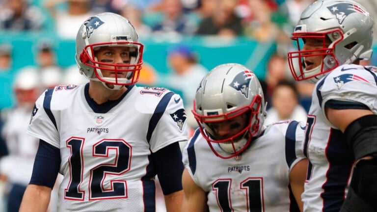 New England Patriots quarterback Tom Brady (12) talks to wide receiver Julian Edelman (11) and tight end Rob Gronkowski (87), during the first half of an NFL football game against the Miami Dolphins, Sunday, Dec. 9, 2018, in Miami Gardens, Fla.