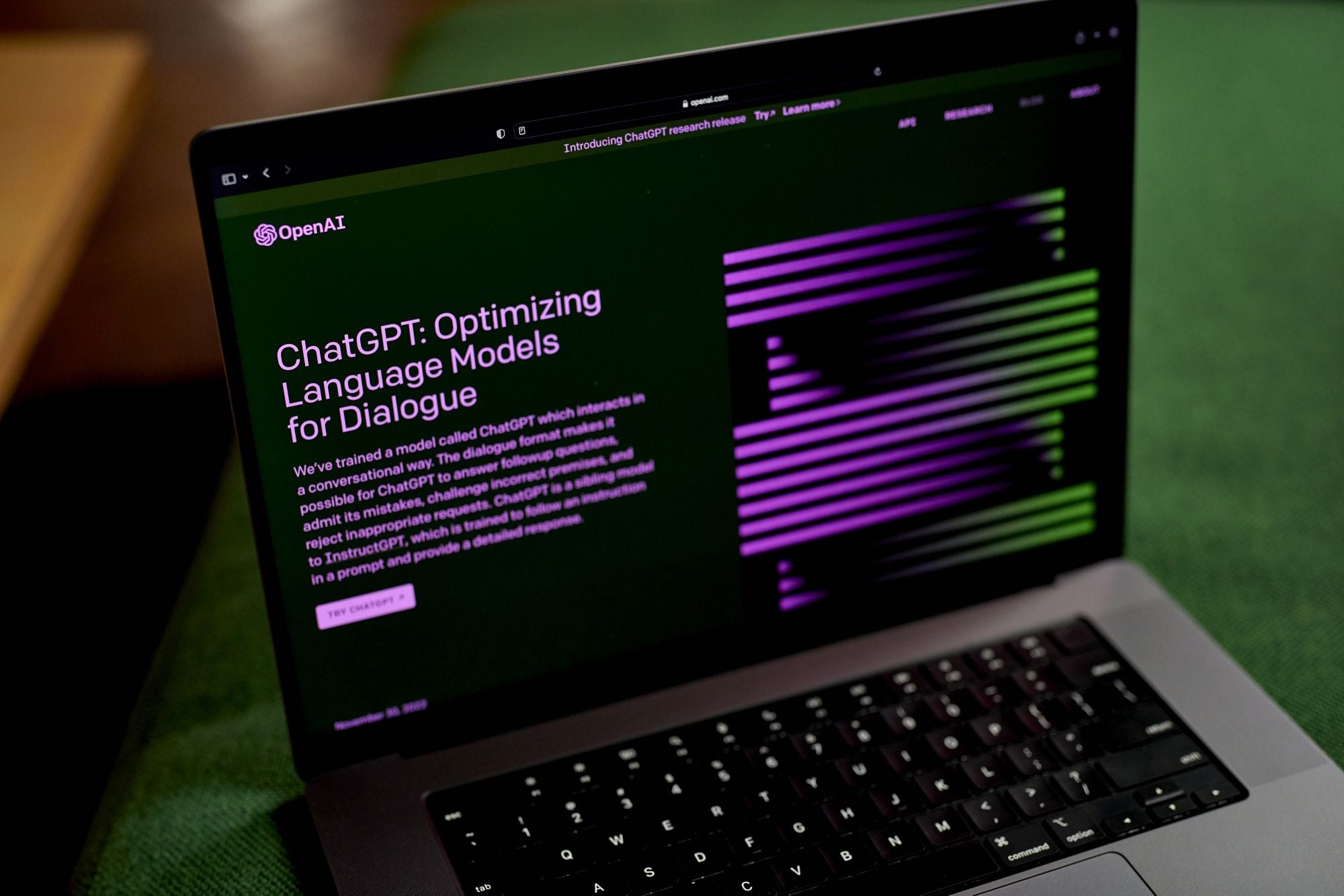 alt = The OpenAI website ChatGPT with a black background and purple and green font on a black laptop computer.