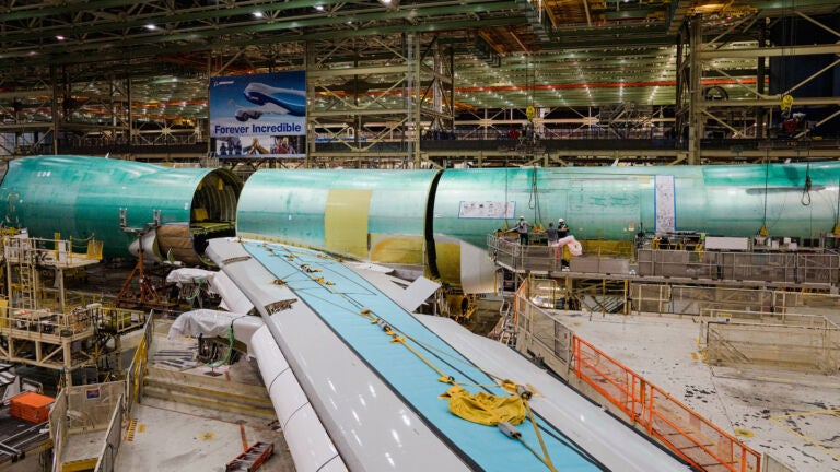 Cranes lift the rear fuselage into position during the final body join of the last 747 jumbo jet at the Boeing factory in Everett, Washington, Sept. 28, 2022.