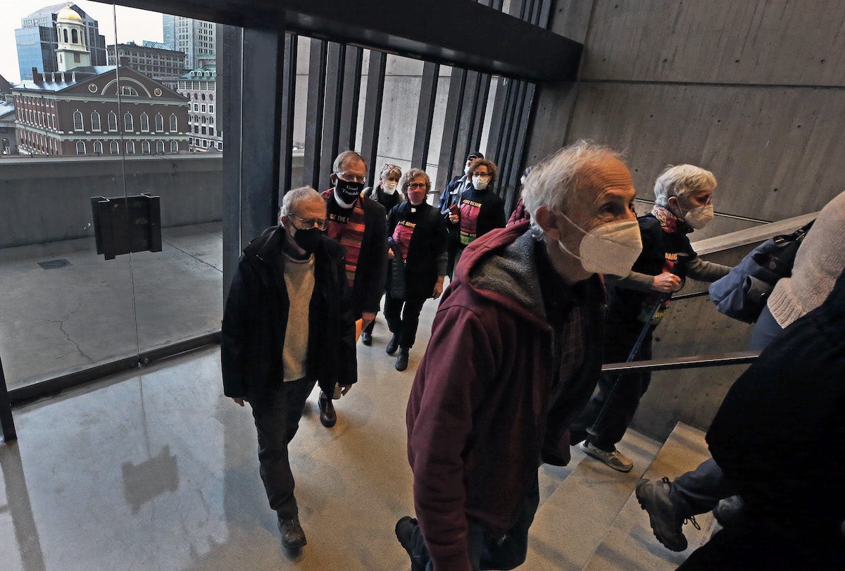 Protestors from The New Democracy Coalition are pictured as they climb the stairs to the fifth floor of Boston City Hall