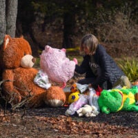 A visitor stops by a makeshift memorial outside the Clancys' Duxbury home on Thursday.