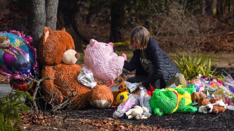 A visitor stops by a makeshift memorial outside the Clancys' Duxbury home on Thursday.