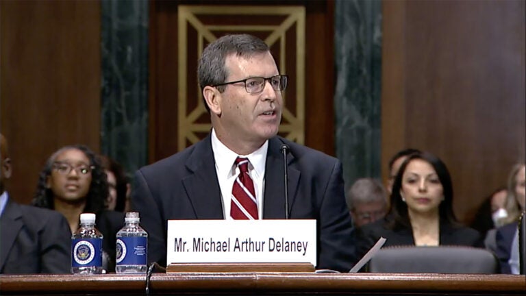 Michael A. Delaney — shown seated at a table in a suit and tie, a name plate in front of him — at his Senate Judiciary Committee hearing on Feb. 15, 2023.