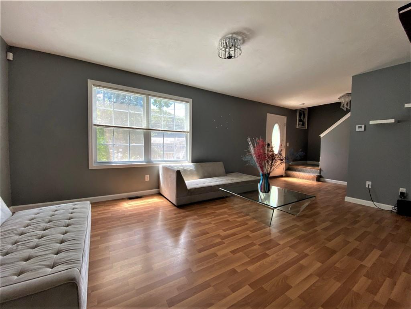 The living room has double-hung windows and dark gray walls with hardwood floors.