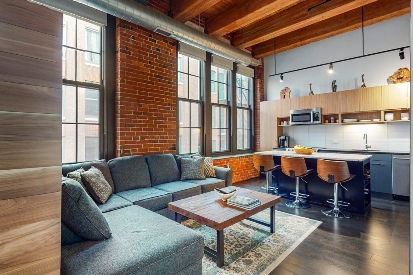 The apartment has exposed brick walls and exposed ceilings.