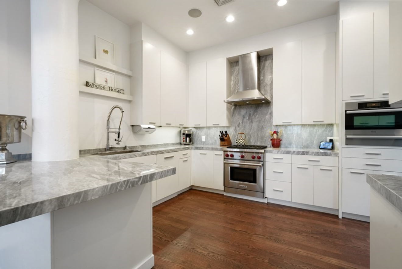 The kitchen has Italian marble countertops, hardwood floors, flat panel cabinets and stainless steel appliances including a wine fridge.