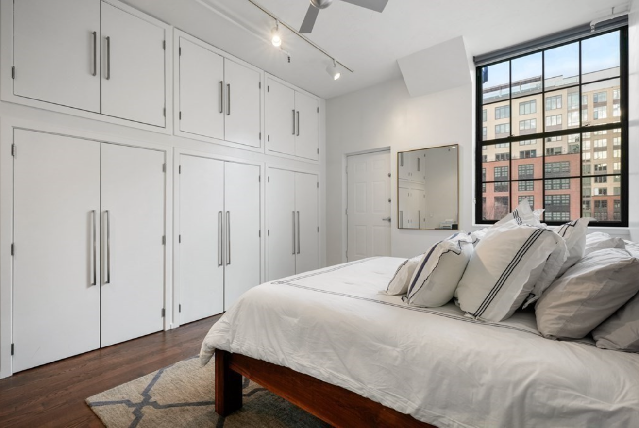 The second bedroom has 12-foot ceilings, picture windows, white walls and built-in closets.