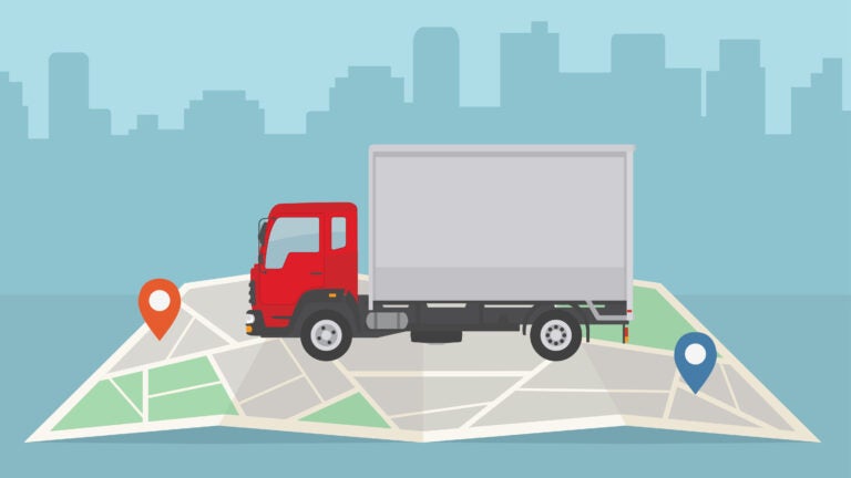 A moving truck with a red cab sits atop a map with the silhouette of a city in the background.