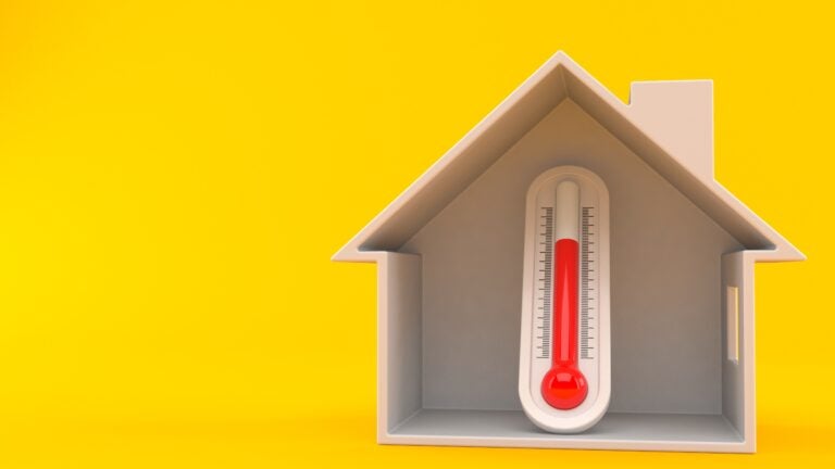 Thermometer inside house cross-section isolated on orange background to show a hot home. 3d illustration