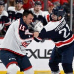 Columbus Blue Jackets defenseman Gavin Bayreuther (15) and Washington Capitals right wing Garnet Hathaway (21) fight during the first period of an NHL hockey game, Sunday, Jan. 8, 2023, in Washington.