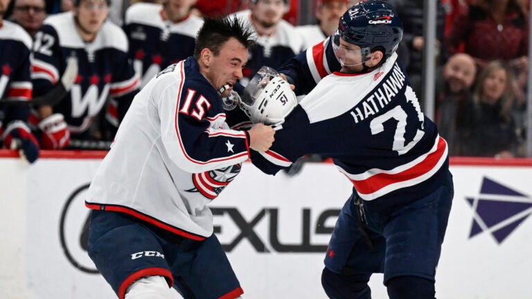 Columbus Blue Jackets defenseman Gavin Bayreuther (15) and Washington Capitals right wing Garnet Hathaway (21) fight during the first period of an NHL hockey game, Sunday, Jan. 8, 2023, in Washington.
