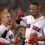 Boston, MA: September 27, 2017: The Red Sox Xander Bogaerts (right) is greeted at the top step of the dugout by teammate Christian Vazquez (left) following his third inning three run home run. The Boston Red Sox hosted the Toronto Blue Jays in an MLB regular season baseball game at Fenway Park.