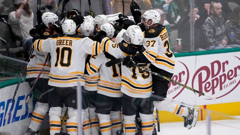 The Boston Bruins celebrate after David Pastrnak scored in overtime of an NHL hockey game against the Dallas Stars, Tuesday, Feb. 14, 2023, in Dallas. The Bruins won 3-2.