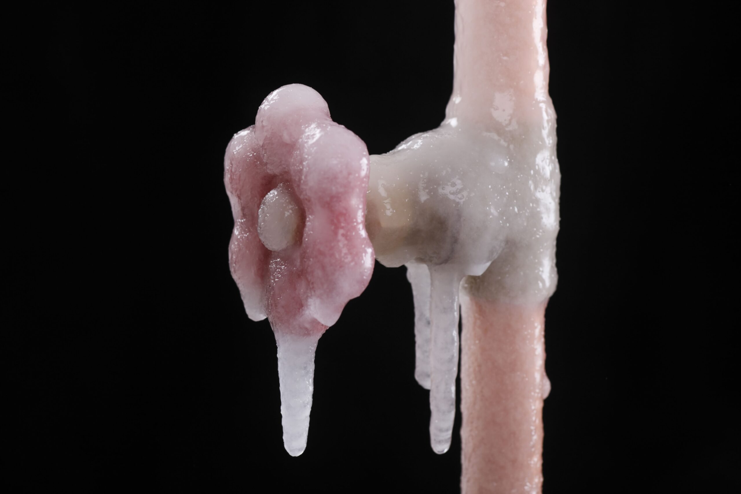A frozen pipe with ice hanging off of it.