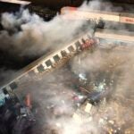 Smoke rises from trains as firefighters and rescuers operate after a collision near Larissa city, Greece, early Wednesday, March 1, 2023.