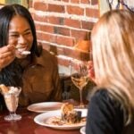 Two women eat together at Grotto in Boston
