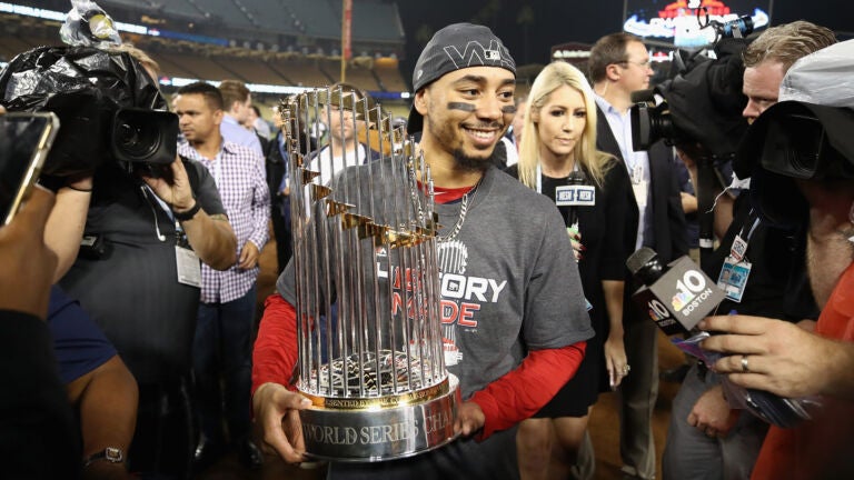 Mookie Betts #50 of the Boston Red Sox celebrates with the World Series trophy after his teams 5-1 win over the Los Angeles Dodgers in Game Five of the 2018 World Series at Dodger Stadium on October 28, 2018 in Los Angeles, California.