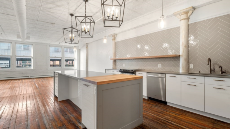 The kitchen at 116 Lincoln St. Apt 3B includes gray herringbone backsplash and stainless steel appliances.