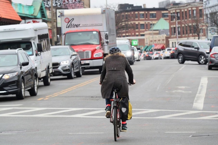 A bicyclist rode down Harvard Avenue.