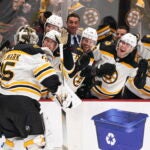 Boston Bruins goalie Linus Ullmark, left, celebrates his empty-net goal against the Vancouver Canucks during the third period of an NHL hockey game Saturday, Feb. 25, 2023, in Vancouver, British Columbia.