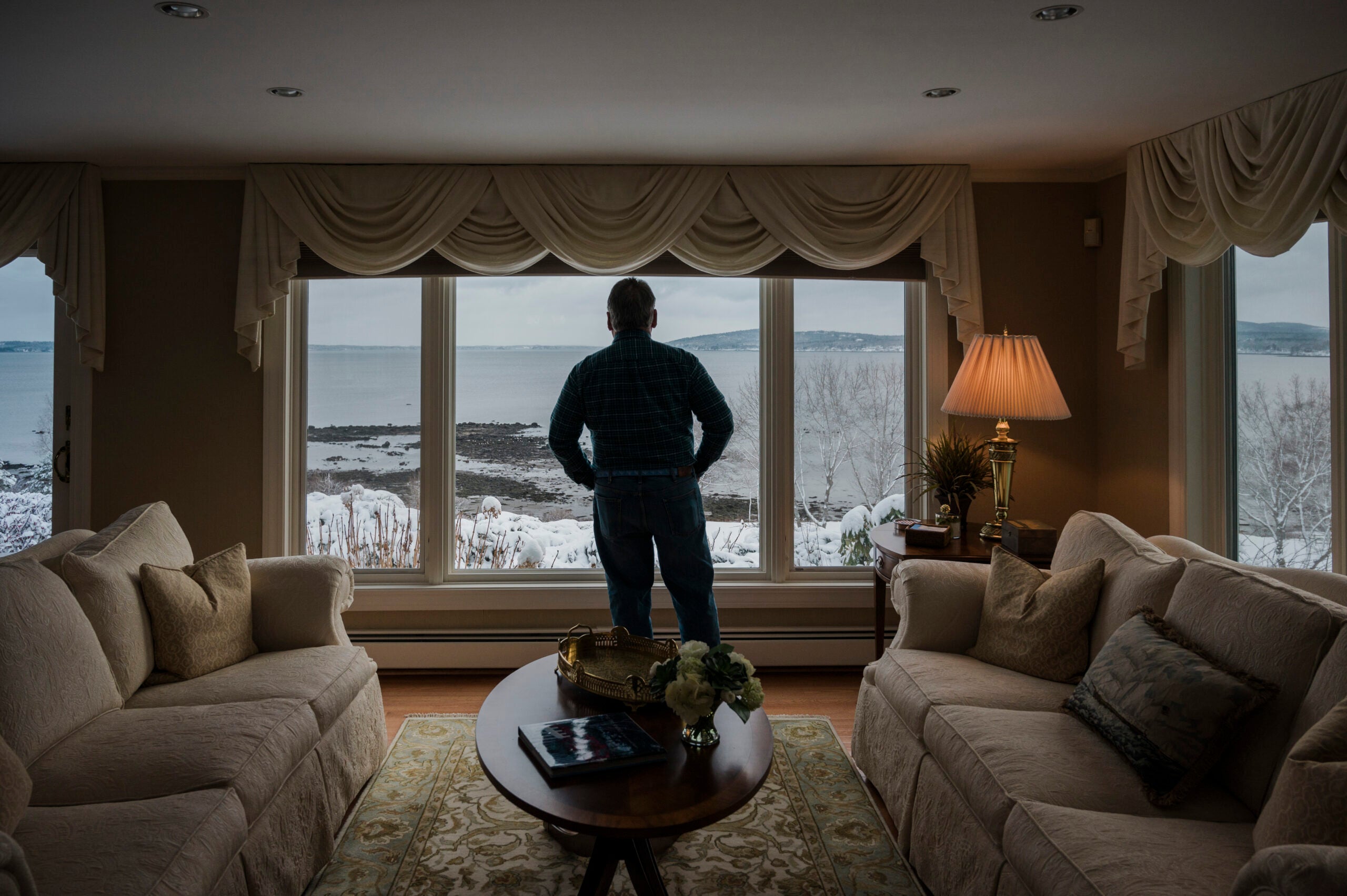 Bob Cochran looks at Penobscot Bay from the living room window of a home in Belfast, Maine, that he and his wife were considering buying.
