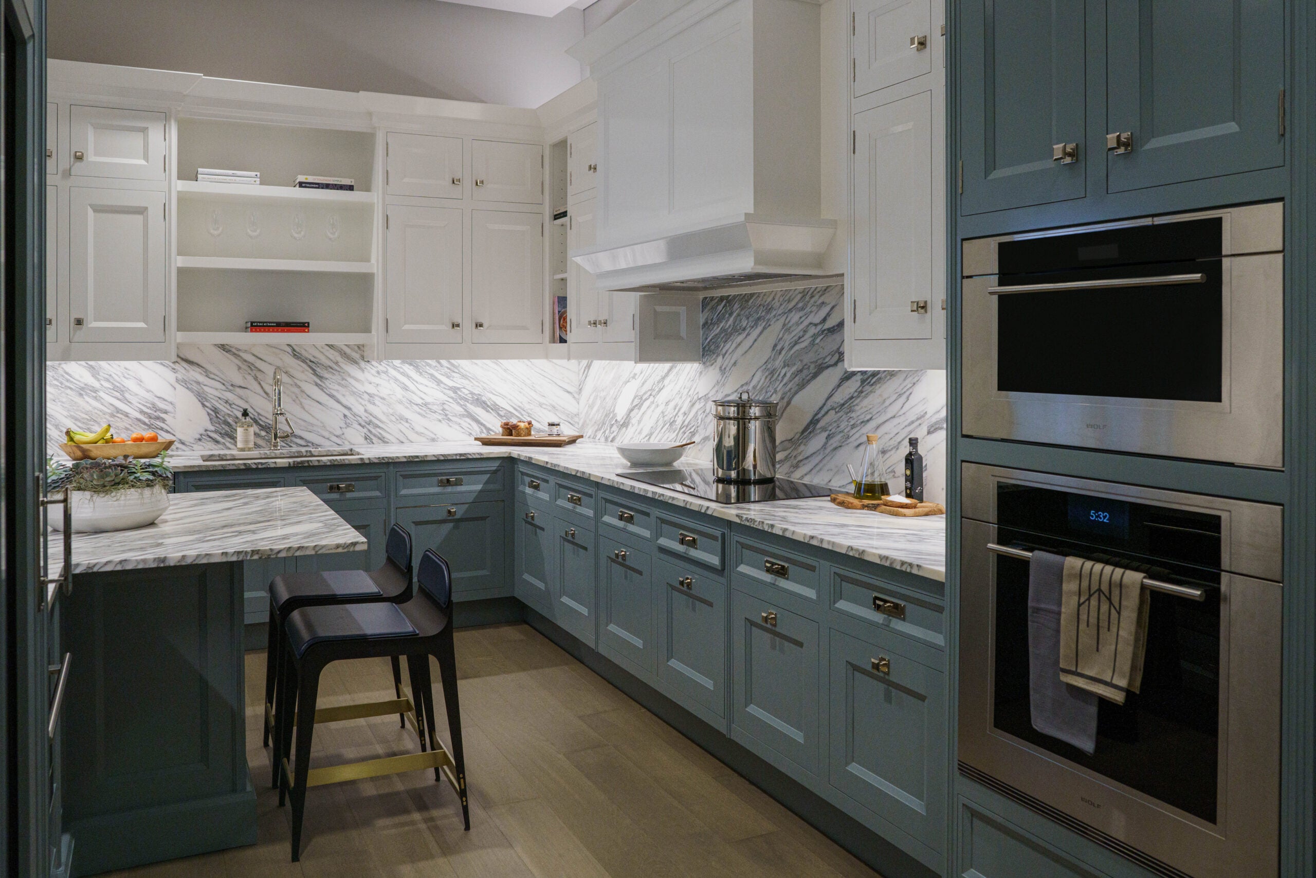 A kitchen with cabinets that are white and a blueish-green.