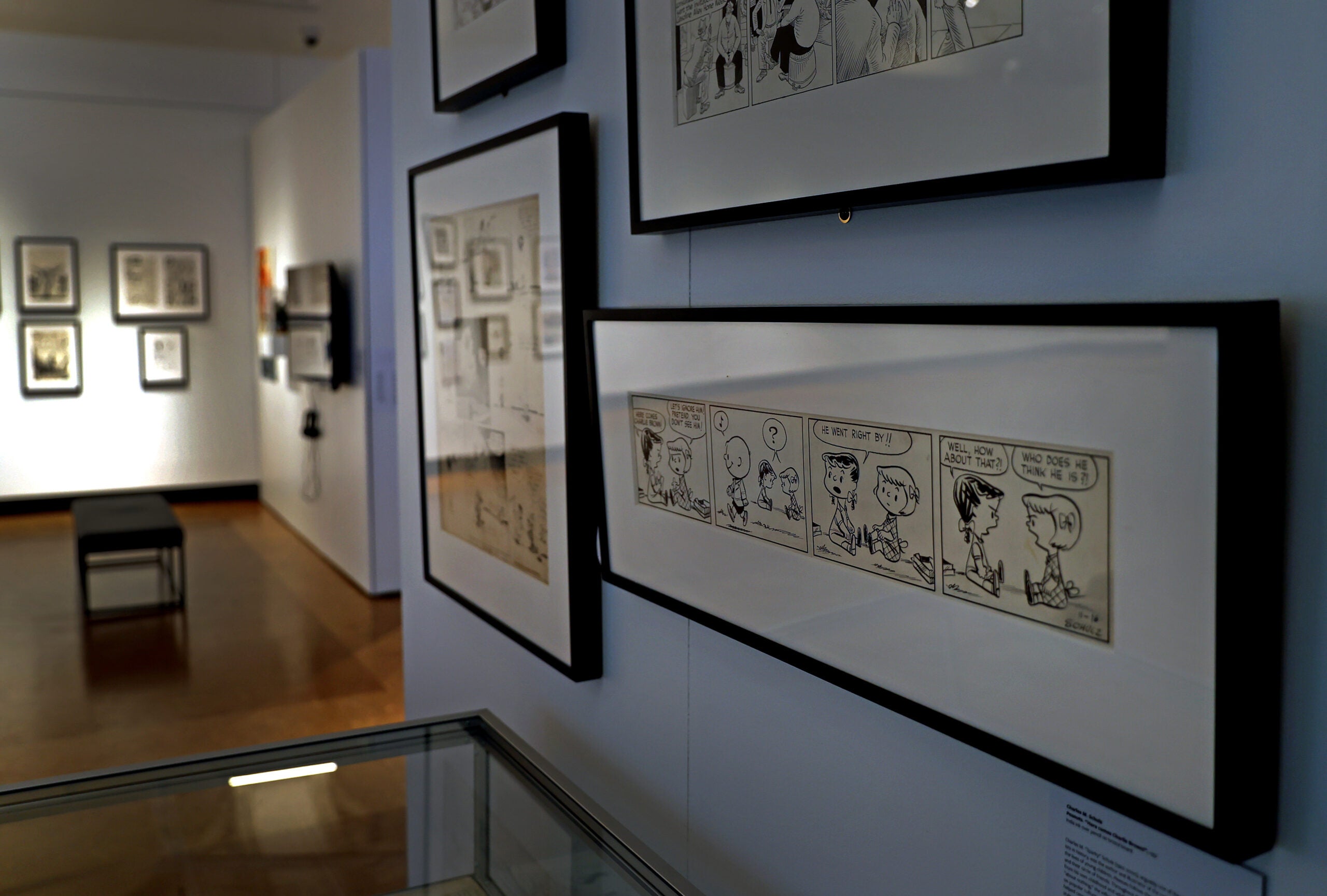 An early "Peanuts" comic strip by Charles M. Schulz hangs on a wall in the exhibition "Comics Is A Medium, Not A Genre" at Boston University