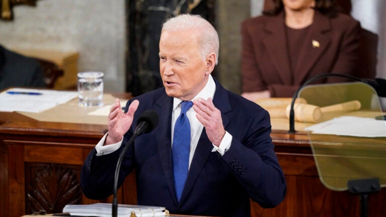 alt = President Biden in a suit with a blue tie talks with his hands as he delivers his State of the Union address to a joint session of Congress on Capitol Hill on March 1, 2022.