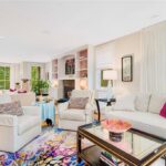 The living room has cream walls and bookshelves with salmon interiors.