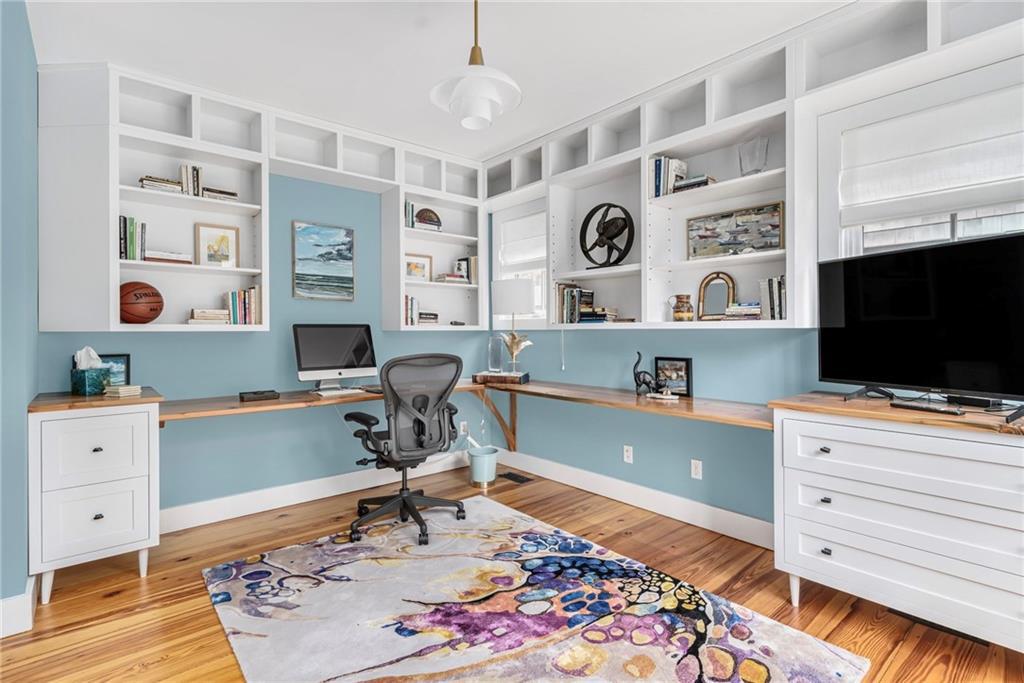 This home office has built-in shelves, hardwood floors and sky blue walls.