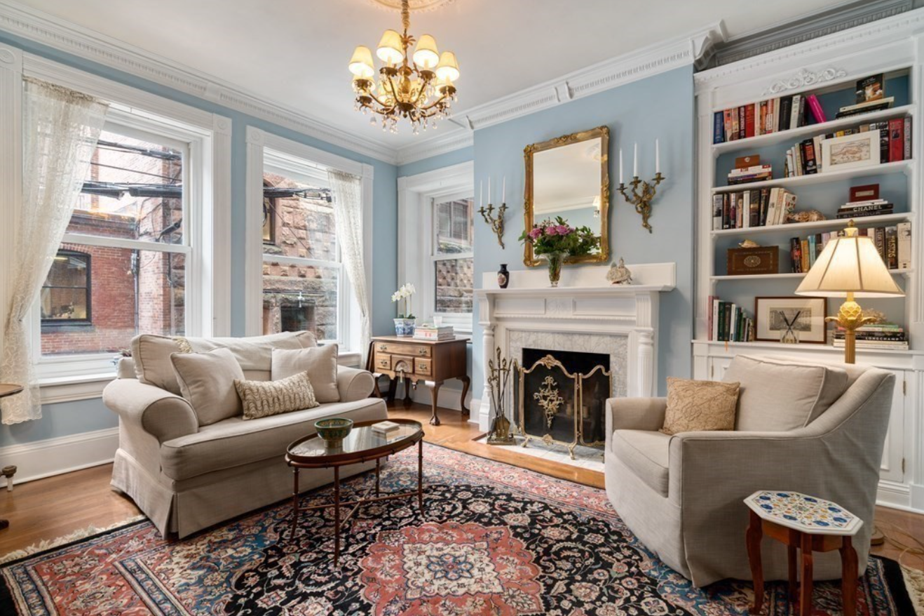 The living room has light blue walls, hardwood floors, white crown molding and a fireplace.