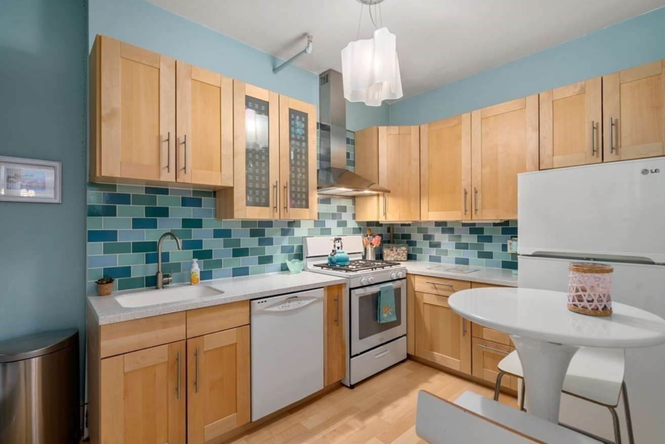 The kitchen has subway tile backsplash in three shades of blue for a bold interior design choice.