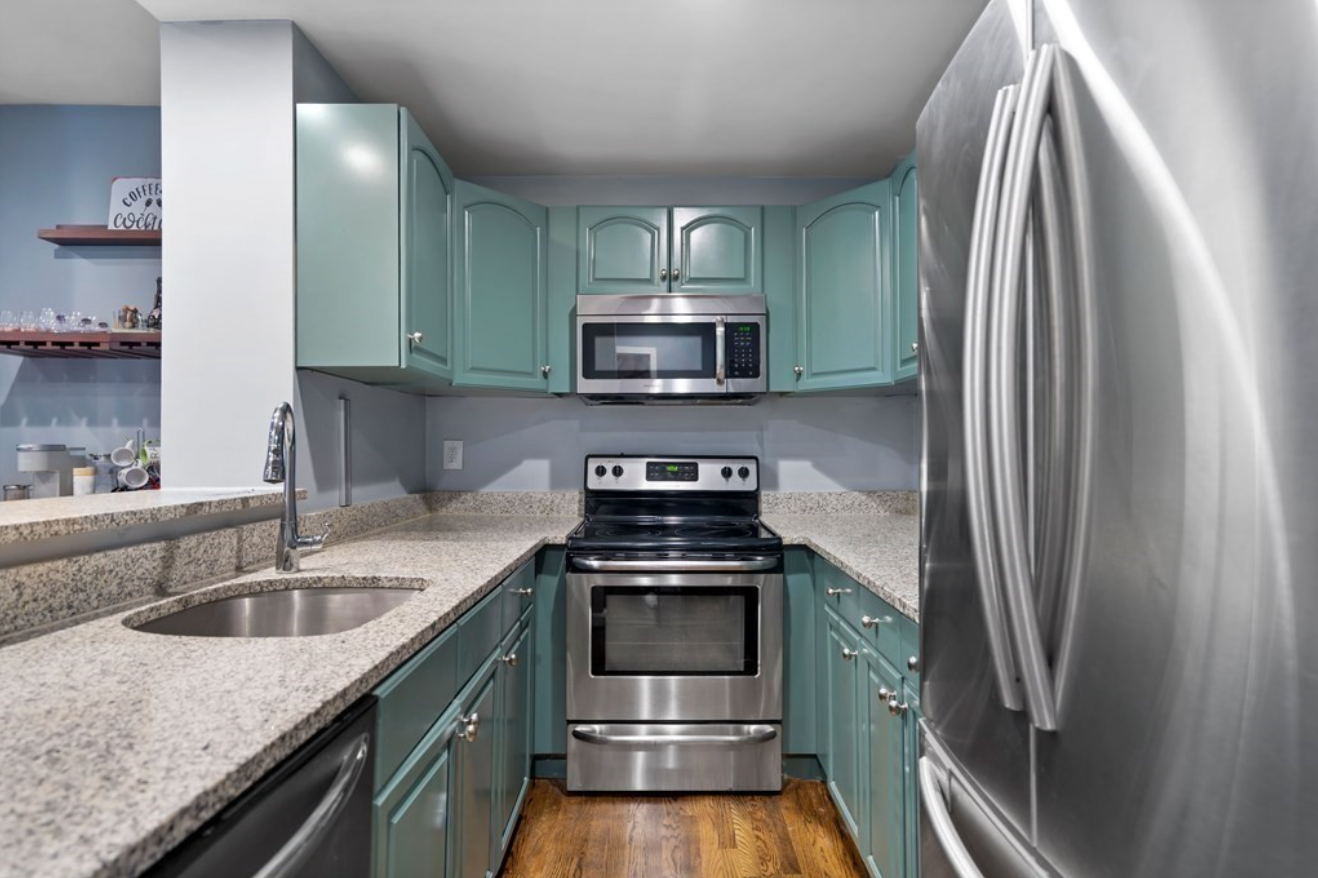 The kitchen has light blue cabinets and stainless steel appliances.