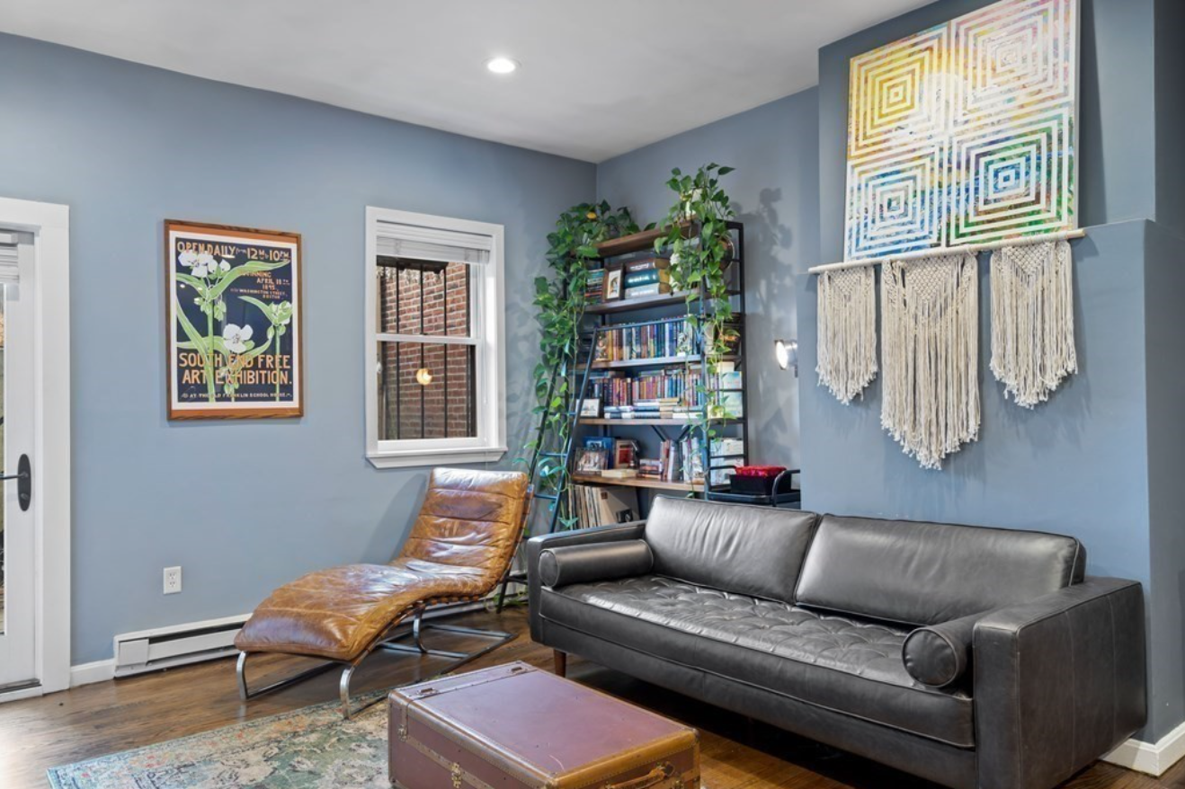 The living room has light blue walls and hardwood floors.